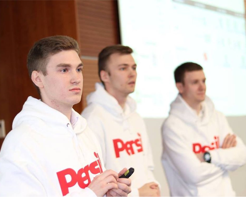 Tres empleados de Henkel vistiendo un suéter Persil y realizando una presentación