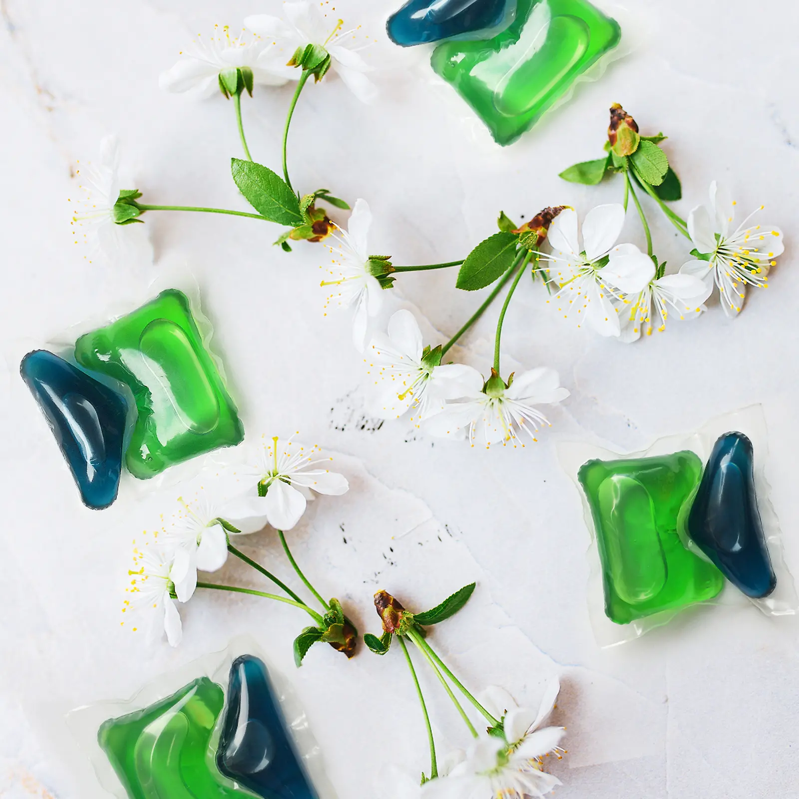 Dos fichas verdes y azules Henkel Persil con flores de cerezo alrededor