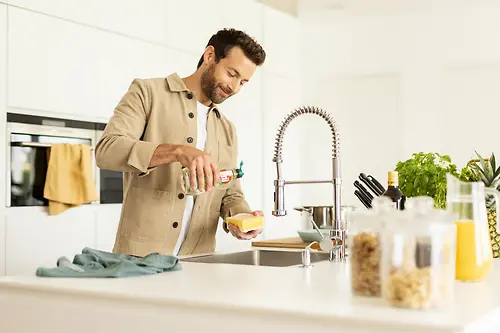 Hombre en la cocina lavando los platos