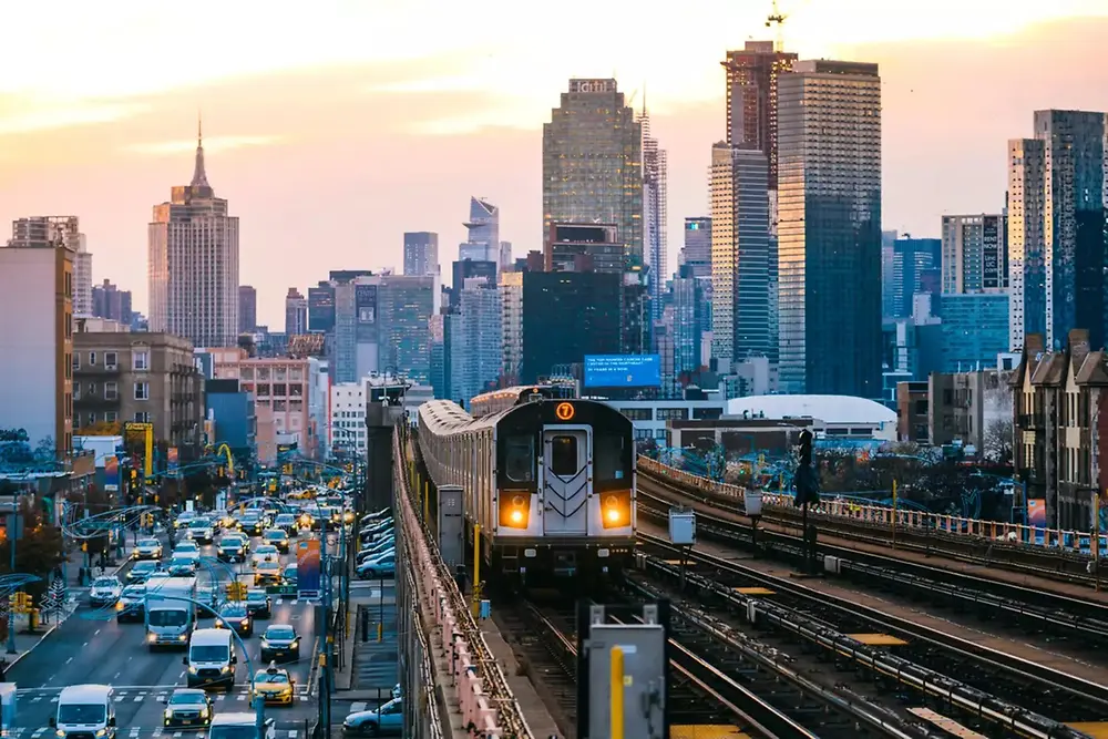 Tren urbano que atraviesa el perfil de una ciudad moderna durante el día.