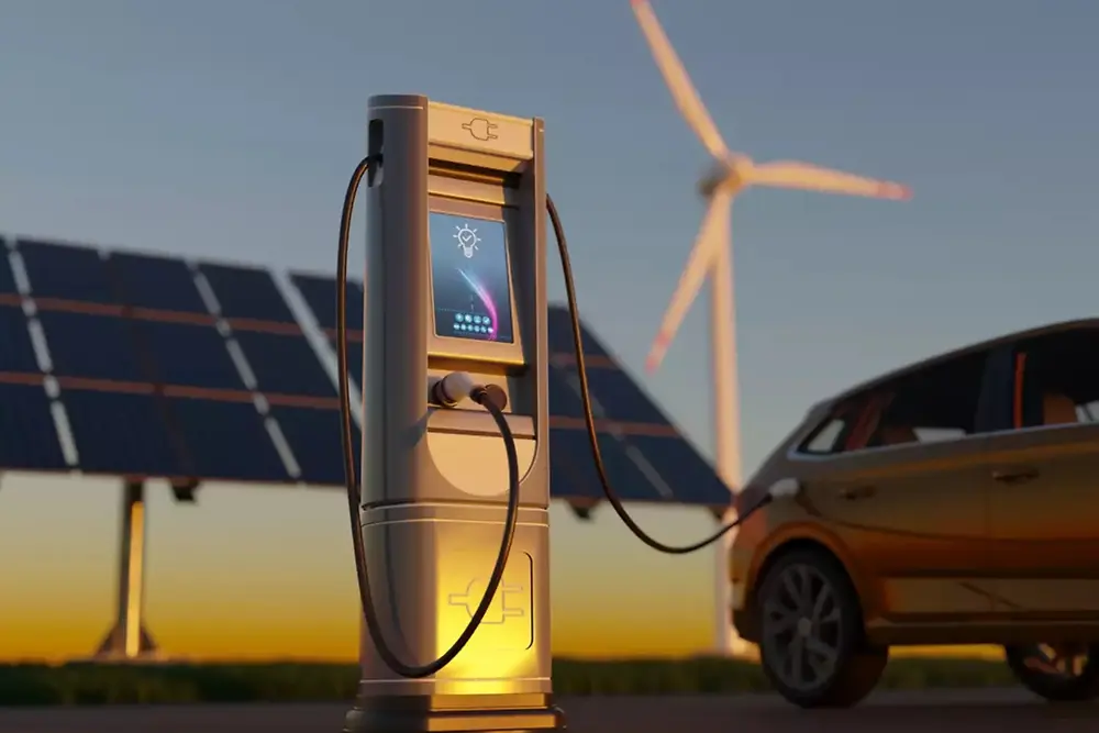 Estación de carga para vehículos eléctricos con paneles solares y aerogeneradores al fondo.