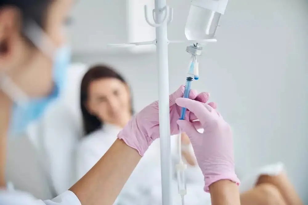 Un profesional sanitario sostiene una bolsa de suero intravenoso en un centro de salud.
