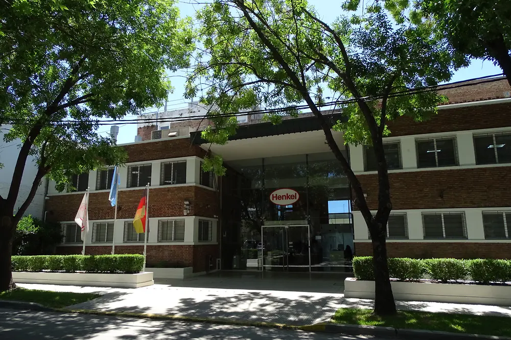 Fachada de las oficinas de Henkel Argentina en San Isidro, con las banderas de Henkel, Argentina y Alemania (izquierda a derecha).